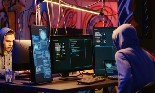 Malicious computer specialists in secret abandoned warehouse working together to get past anti tamper measures implemented by companies to protect their software, uploading crack to torrent websites